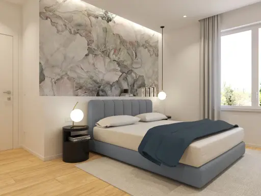 Idee per cosa mettere su un comò in camera da letto: un tavolino nero con lampada, libri e un vaso con fiori secchi.