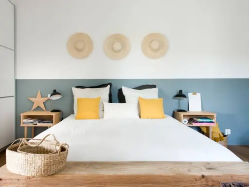 Décoration murale avec trois chapeaux de paille pour comment donner de la hauteur à un plafond bas. Chambre moderne et lumineuse.