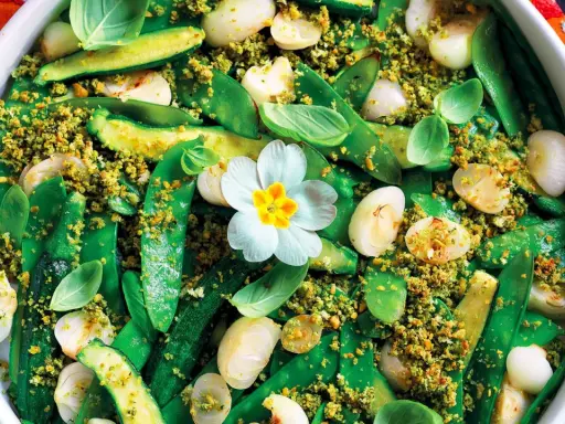 Un colorato contorno di verdure miste, con piselli, zucchine e cipolline, condito con pangrattato croccante. Un pranzo della domenica fatto in casa da Benedetta, con un fiore decorativo.