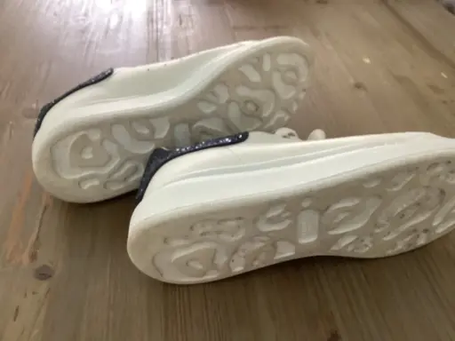 Białe sneakersy Alexander McQueen z granatowymi brokatowymi wstawkami. Zwróć uwagę na charakterystyczną podeszwę, by jak rozpoznać oryginalne buty Alexander McQueen.