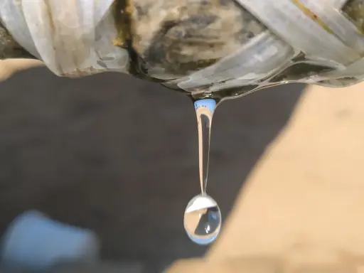 Gota de agua cayendo de una tubería rota, indicando la necesidad de reparar tubería.