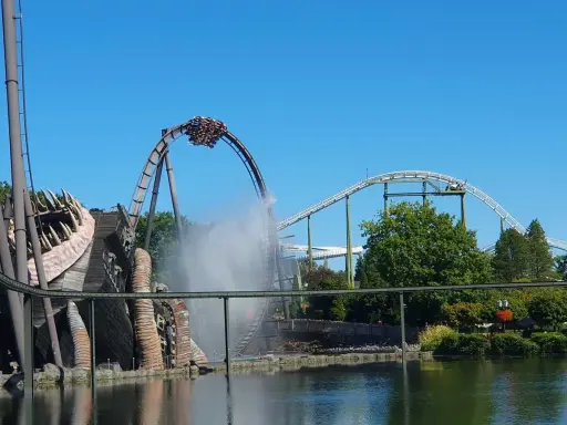 Achterbahn im Heide Park mit Wassereffekt und einem großen Holzmonster.