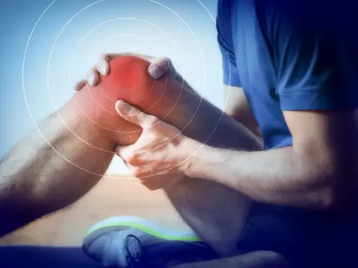 Ból kolana sportowca, który wymaga rehabilitacji sportowej. Czerwony obszar i kręgi wskazują na uraz.