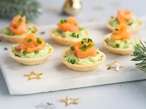Canapés de salmón y aguacate, un picoteo fácil y rápido para cualquier celebración. Decorados con cebollino y estrellas doradas.