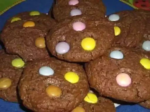Gros plan sur des cookies chocolat garnis de Smarties colorés. Un délice gourmand pour petits et grands.