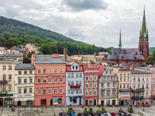 Kolorowe kamienice i kościół z zieloną wieżą tworzą malowniczy widok. Odkryj teraza ruda atrakcje!