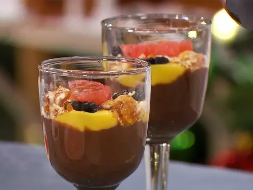 Två glas med chokladpudding, toppad med mango, bär, nötter och grapefrukt. Ett perfekt chokladpudding recept för fest!