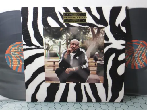 Płyta winylowa "Piñata" Freddie Gibbs & Madlib z charakterystycznym wzorem zebry. Na okładce zdjęcie rapera.