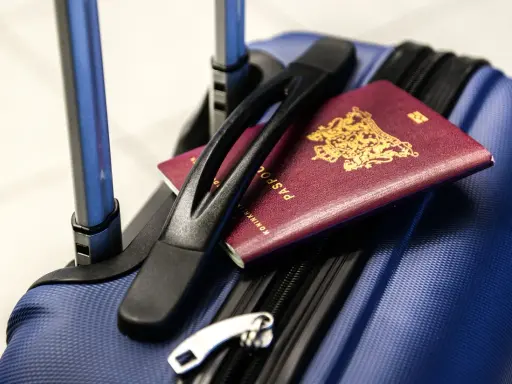 Bagaż rejestrowany Pegasus Airlines gotowy do podróży. Paszporty leżą na niebieskiej walizce, czekając na odprawę.