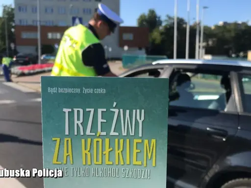 Policjant kontroluje kierowcę. Plakat informuje: "Trzeźwy za kółkiem". Co to znaczy trzeźwy? To bezpieczeństwo na drodze.