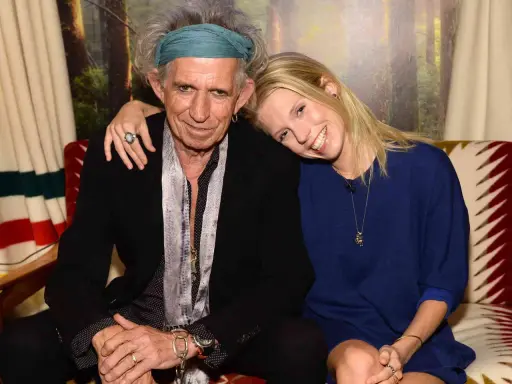 Keith Richards och en ung kvinna ler mot kameran. Hon vilar huvudet mot hans axel.