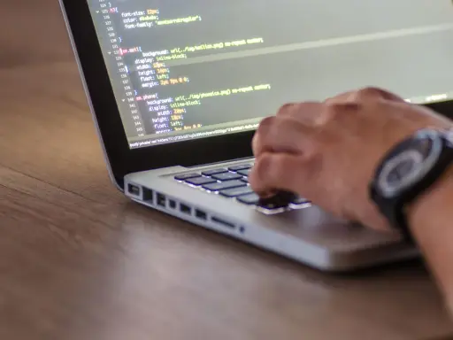 Dłoń pisze kod CSS, optymalizując pliki do wersji min.