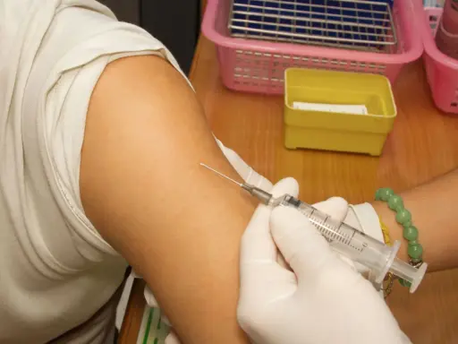 Spritze wird in den Arm einer Person eingeführt, die eine Hyposensibilisierung gegen Asthma erhält.