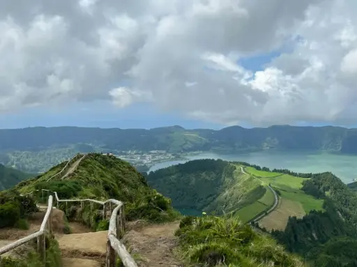 Widok na jezioro Sete Cidades, Azory, Ponta Delgada. Ścieżka z barierkami prowadzi na szczyt z panoramą zielonych wzgórz i wody.