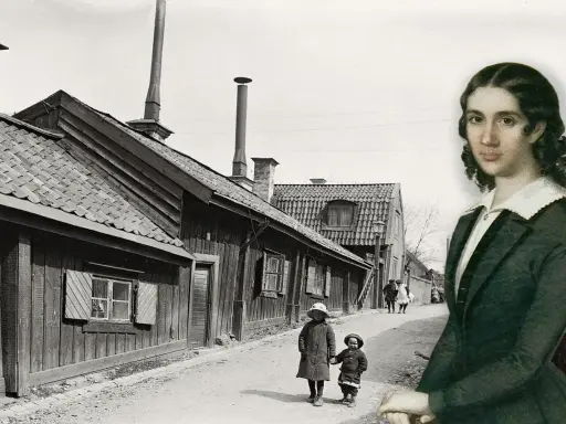 En kvinna, kanske Wendela Hebbe, betraktar en gammal svensk stadsgata med barn som leker.