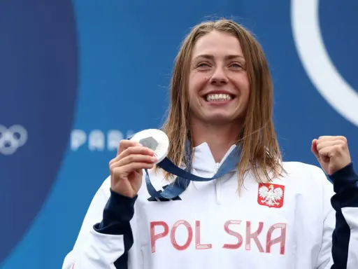 Uśmiechnięta sportsmenka z Polską na piersi i medalem olimpijskim w dłoni. To dopiero początek drogi do emerytury za medal olimpijski!