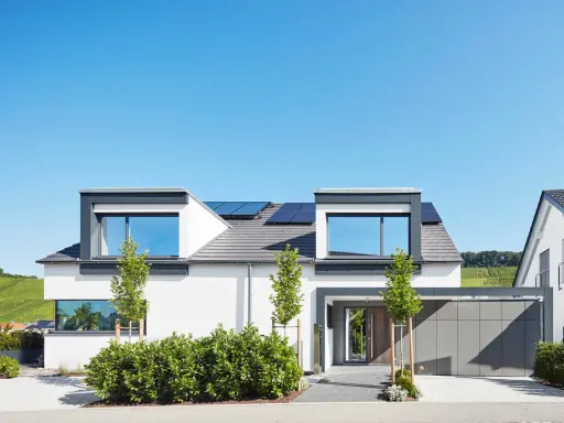 Modernes Einfamilienhaus mit Solaranlage, gestaltet von einem erfahrenen hausbau architekt. Klare Linien und viel Licht prägen das Bild.