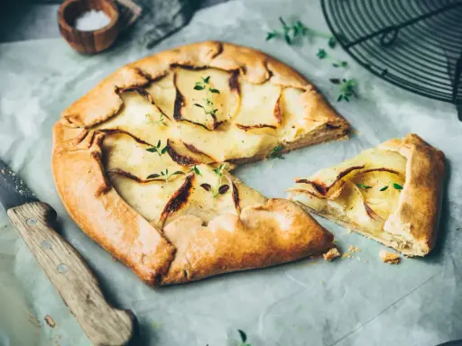 Galette aux pommes, recette de maman, dorée et garnie de fines tranches de pommes, prête à être dégustée.