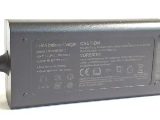Graues Netzteil mit der Aufschrift "Output: 54.6V 1.5A". Dieses Netzteil 12V 5A ist für Li-ion Akkus.