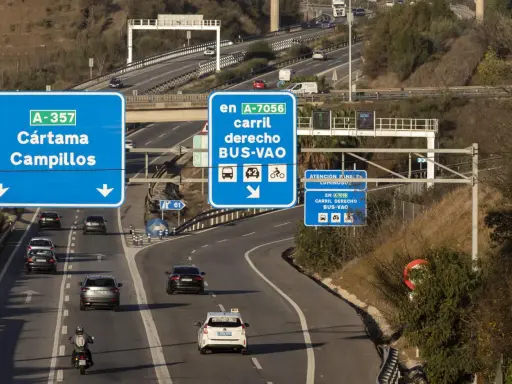 Carril derecho BUS-VAO en A-7056, con distintivo ambiental B. Señalización de tráfico en autopista.