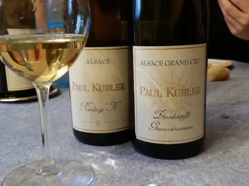 Verre de vin blanc et deux bouteilles Paul Kubler, Riesling et Gewurztraminer. Quel vin pour cuire la choucroute ? Le Gewurztraminer est un excellent choix.