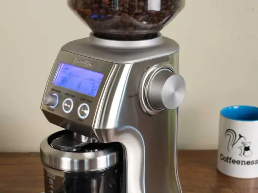 Sage Smart Grinder Pro: Mahlgrad für Espresso einstellen. Die Anzeige zeigt 78.4, 8 und 12. Daneben eine Kaffeetasse mit Eichhörnchen.