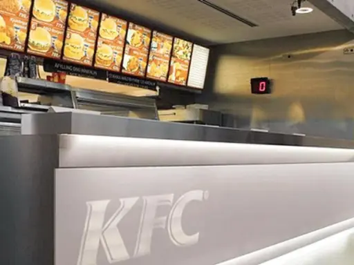 Mostrador de KFC con menú digital y cartel de "0". El food court significado es un área de comida.