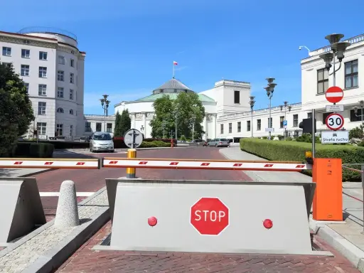 Przed Sejmem RP, gdzie dyskutuje się, ile wynosi dieta poselska, szlaban i znak STOP.