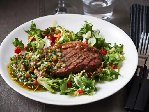 Perfekt grillad picanha med en fräsch sallad och chimichurri. En härlig måltid att njuta av.