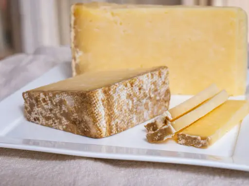 Tranches de Cantal, une des spécialités du Cantal, sur une assiette blanche.