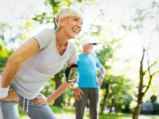 Glückliche Frau und Mann beim Joggen im Alter im Park. Sie genießen die Natur und die Bewegung.