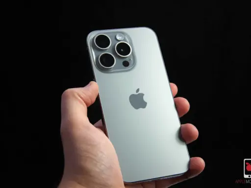 Dłoń trzyma srebrny iPhone 15 Pro z widocznym modułem aparatów i logo Apple. Dynamic Island na ekranie tego modelu to innowacja.