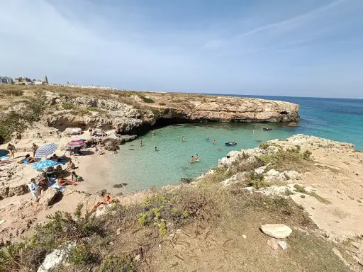 Una splendida giornata alla spiaggia di Porto Verde, con bagnanti che si godono il sole e le acque cristalline.