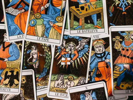 Rozłożone karty tarota, w tym "Le Pape" i "Le Bateleur", sugerują pytania: "tarot co on do mnie czuje?".