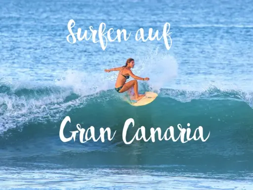 Surfen auf Gran Canaria: Eine Frau surft auf einer Welle, umgeben von Gischt.