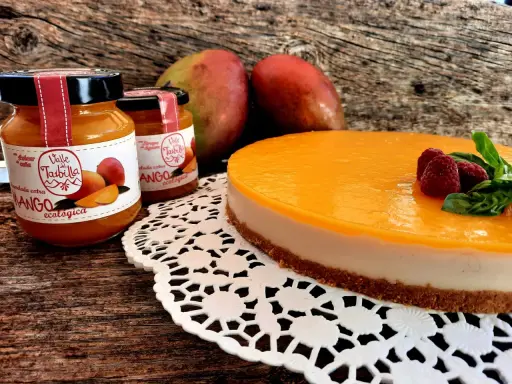 Deliciosa tarta de mango y queso, con mermelada ecológica de mango y frambuesas frescas.