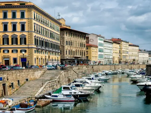 Edifici storici e barche ormeggiate lungo il canale del **terminal crociere Livorno**.
