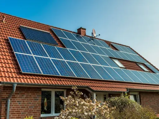 Ett tegelhus med solpaneler på taket, en del av solenergi historia.