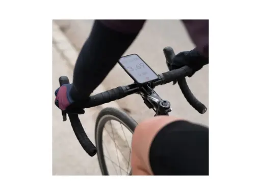 Rowerzysta trzyma kierownicę, na której zamontowano telefon za pomocą uchwytu sp connect. Na ekranie widoczny czas i prędkość.