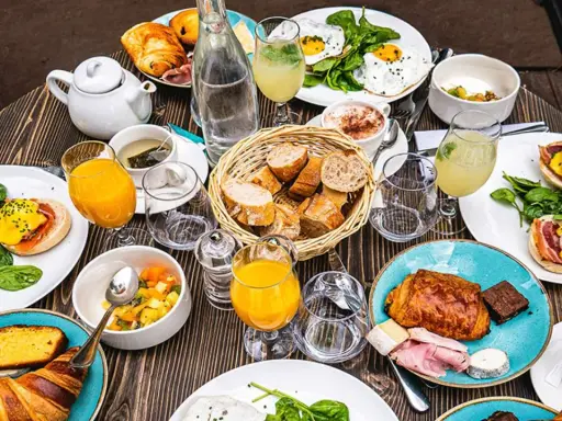 Un festin matinal parisien : œufs Bénédicte, croissants, jus d'orange et café. Un plat typique de Paris pour bien commencer la journée.