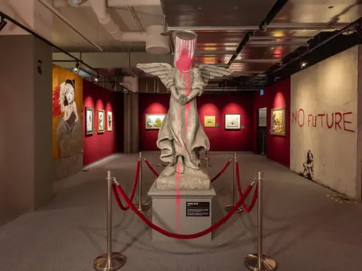 Banksy-utställning i Stockholm med en skulptur av en ängel med en färgburk på huvudet och texten "NO FUTURE".