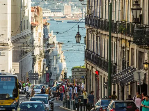 Ein belebter Tag in Lissabon, wo die portugiesischen Einwohner die engen Gassen mit ihren historischen Gebäuden und dem Blick auf das Wasser beleben.