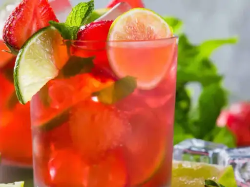 Två glas med en uppfriskande strawberry mojito, garnerade med jordgubbar, lime och mynta. Perfekt för en varm sommardag.