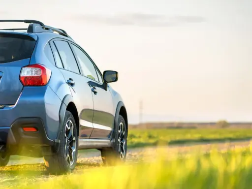 Niebieski SUV na tle pola. Chcesz wiedzieć, jak sprawdzić zniżki OC?