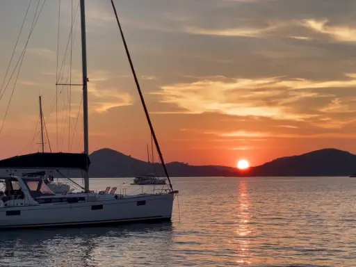 Voiliers au coucher du soleil, une scène paisible pour apprendre comment mouiller rapidement.