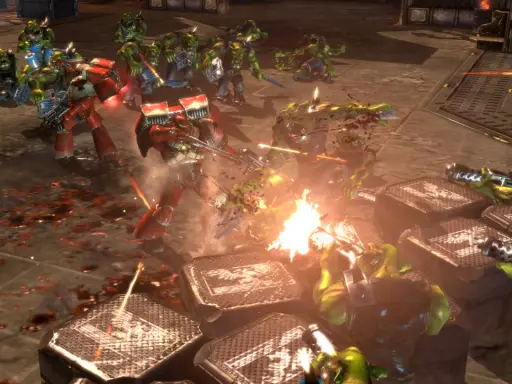 Intensywna bitwa w Dawn of War 2: Kosmiczni Marines walczą z Orkami. Krwawa jatka na polu bitwy.
