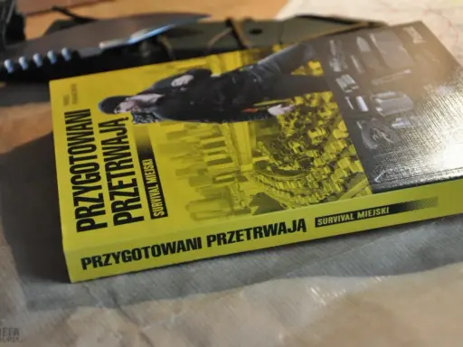 Książka "Przygotowani przetrwają. Survival miejski" leży obok noża. Podręcznik do przetrwania w miejskiej dżungli.