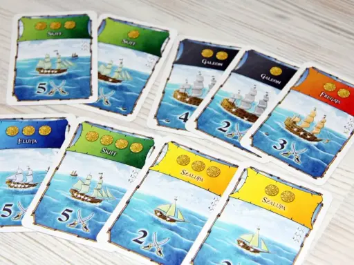 Karty do gry "Port Royale" przedstawiające statki: fluitę, skiff, galeon, szalupę i fregatę, gotowe do morskiej przygody.