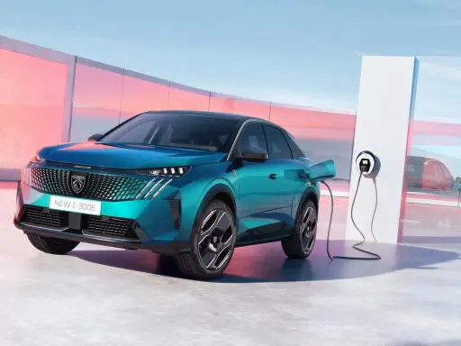 Un nuevo Peugeot E-3008 eléctrico enchufable, de color azul turquesa, cargando en un moderno punto de recarga.