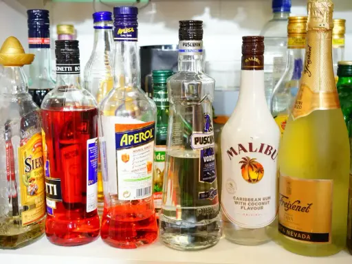 Różnorodne butelki alkoholi: Aperol, Malibu, Puschkin, Freixenet. Ile setka ma procent? To zależy od zawartości butelki!